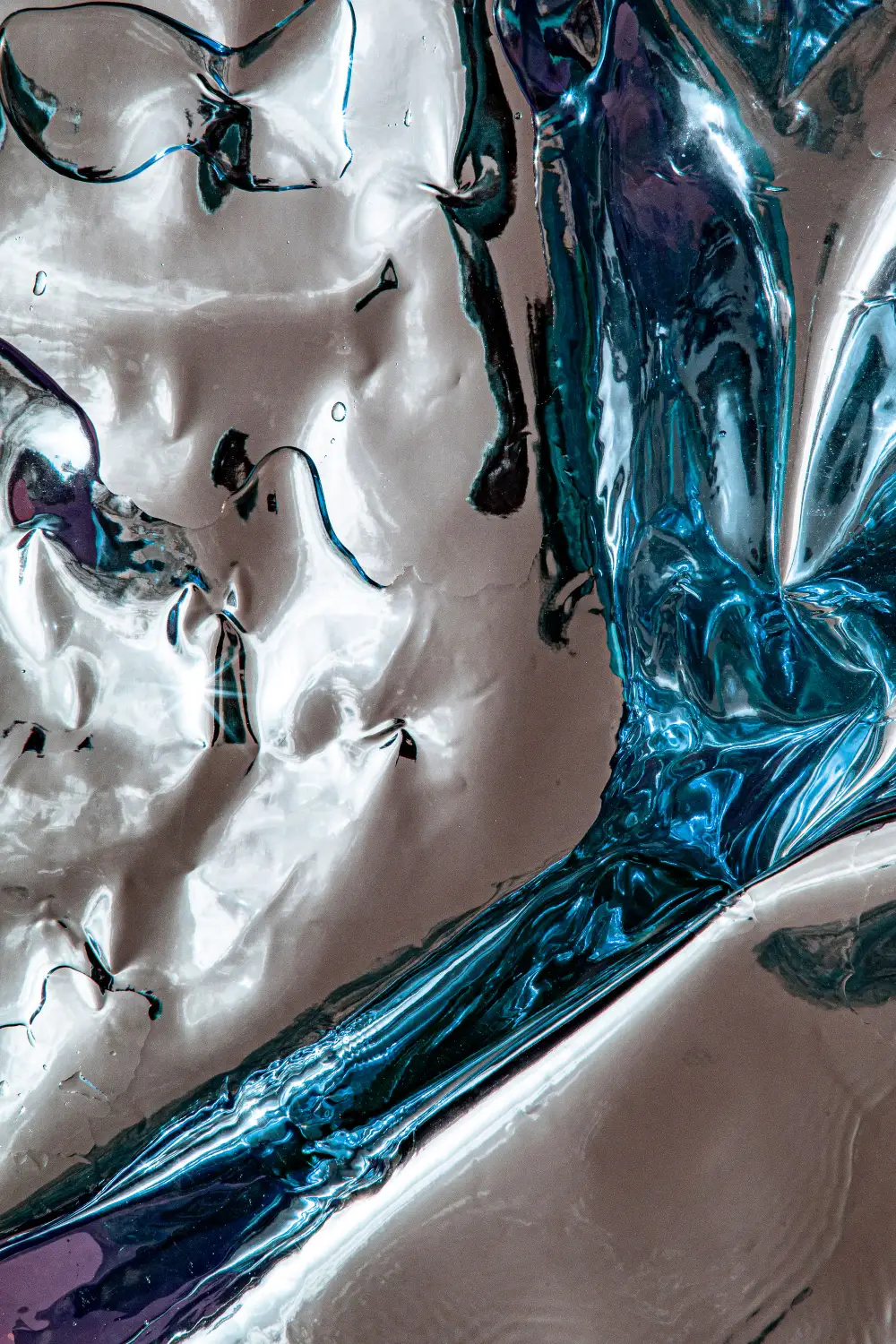 Flüssig wirkendes Chrom mit blauen Reflexen in Nahaufnahme